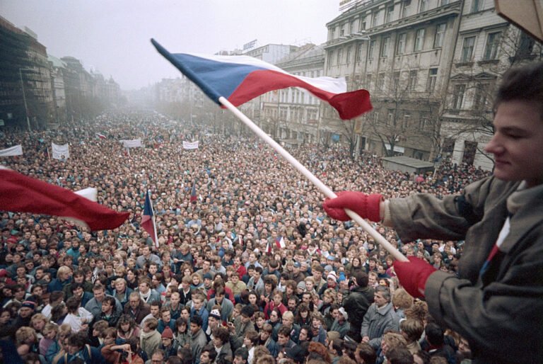 Man Waving Czech Flag Above Crowd