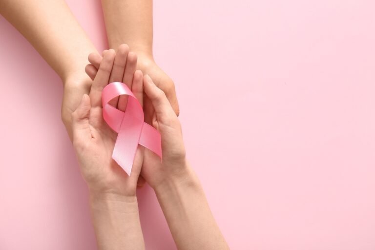 Women,Holding,Pink,Ribbon,On,Color,Background,,Closeup.,Breast,Cancer